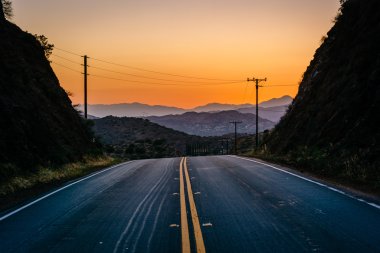 Sunset over distant mountains and Escondido Canyon Road, in Agua clipart
