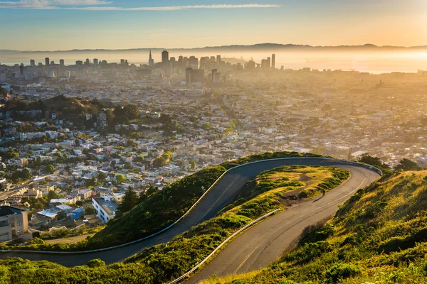 Curvy road and view of downtown at sunrise from Twin Peaks, in S — Stock Photo, Image