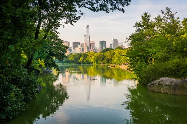 Edifícios refletindo em The Lake, no Central Park, em Manhattan , — Fotografia de Stock