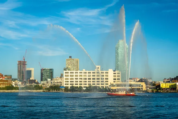 Fire boat spraying water over the East River, seen from Roosevel — Stock Photo, Image