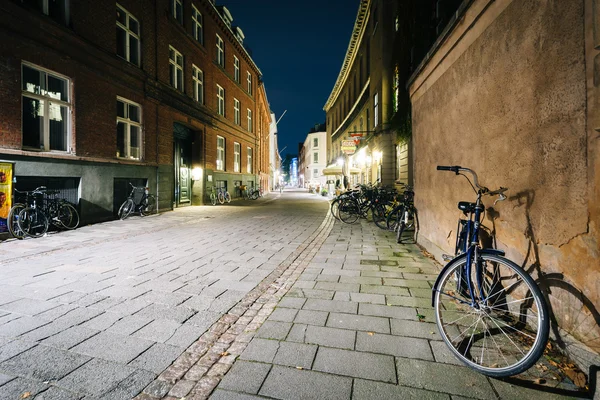 Bicicleta estacionada a lo largo de una calle estrecha por la noche, en Copenhague, De —  Fotos de Stock
