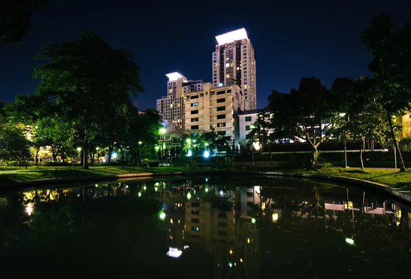 Lagoa no Santiphap Park e arranha-céus à noite, em Bangkok, Tha — Fotografia de Stock