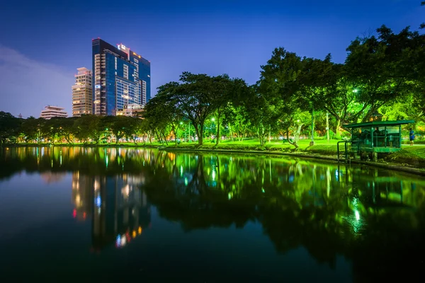 Lake en wolkenkrabbers in de nacht, op Lumphini Park, in Bangkok, Tha — Stockfoto