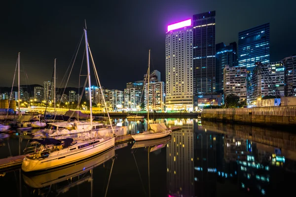 Båtar och byggnader speglar på Causeway Bay på natten, i Hong — Stockfoto