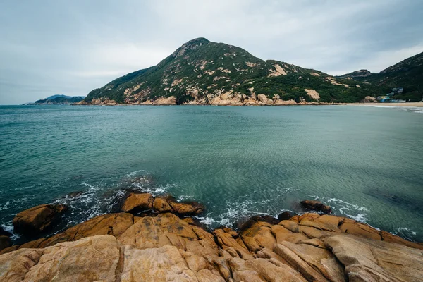 Klippkust och syn på D'Aguilar topp, på Shek O Beach, om Hon — Stockfoto