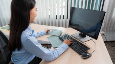 Bilgisayarla çalışan ve ofiste program geliştirmek için veri kodları yazan Asyalı kadın programlama, teknoloji kavramı