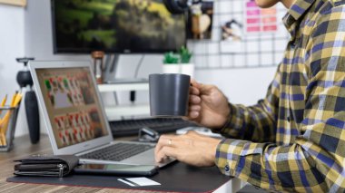 Bilgisayarlı online alışveriş için kredi kartı tutan Asyalı bir adam güvenlik kodu, internet bankacılığı veya ev tüketicisi ticaret konseptinden iş giriş yapıyor.