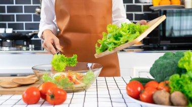 Sağlıklı yemek hazırlayan bir kadın. Sebze salatası. Salata, ahşap kaşık..