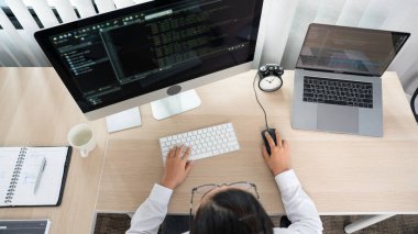 Ofisteki bilgisayarda kaynak kodlar yazan Asyalı Kadın programcı, serbest ağ geliştirici kavramı 