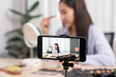 Asyalı kadın güzellik kozmetik ürününü sundu ve internet üzerinden sosyal ağa canlı yayın yaptı, güzellik blogcusu konsepti