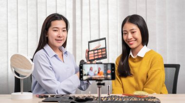 Kozmetik ürünleri üzerine blogları için video hazırlayan genç Asyalı kadın, internet üzerinden canlı yayın yapıyor. Ev güzelliği blogcusu kavramında.