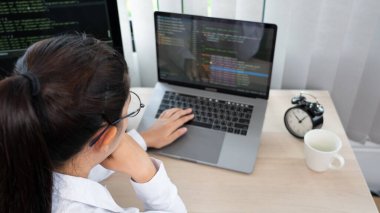 Ofisteki bilgisayarda kaynak kodlar yazan Asyalı Kadın programcı, serbest ağ geliştirici kavramı 