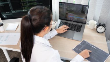 Ofisteki bilgisayarda kaynak kodlar yazan Asyalı Kadın programcı, serbest ağ geliştirici kavramı 