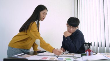 Takım tasarımcısı, iş yerindeki iş araçları ve ekipmanlarla yeni projede renk grafiği üzerinde çalışıyor