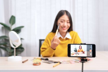 Asyalı kadın güzellik kozmetik ürününü sundu ve internet üzerinden sosyal ağa canlı yayın yaptı, güzellik blogcusu konsepti