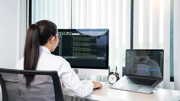 Asian Woman programmer typing source codes Programming On Computer in office, freelance web developer concept
