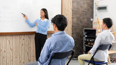 Eğitim konsepti. Covid-19 salgınından önce sınıfta zor matematik kararını açıklayan zeki bir bayan öğretmen..