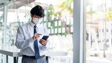 Coronavirus salgınının (COVID-19) koruyucu maske takarak iş hayatına etkisi hakkında ortağıyla sohbet eden bir işadamı konsepti.