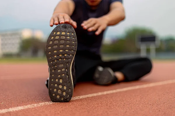 運動前の準備として体の各部分を伸ばすことによってウォーミングアップを行う男性の若者のスポーツやレクリエーションの概念 — ストック写真