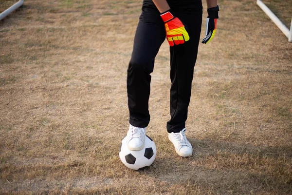 在足球场上 一个穿着白色运动鞋的球被一只脚挡住了 — 图库照片