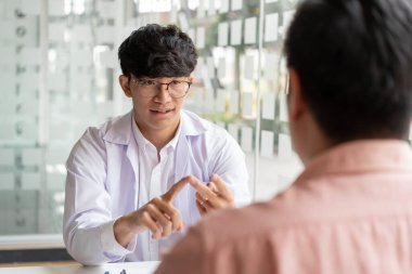 Reçete, semptomları açıklayan ve reçeteyi erkek hastaya veren bir erkek doktor..