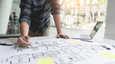 Büyük ve karmaşık bir plan çizen ve tasarlayan bir el..