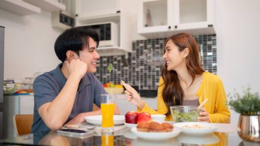 Neşeli Asyalı yetişkinler sağlıklı, lezzetli, modern, taze yiyecekleri ve mutlu anları birleştiren mutfağı paylaşıyorlar.