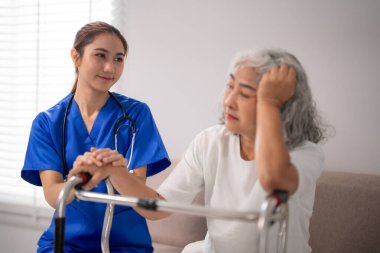 Merhametli Asyalı hemşire, yaşlı kadın hastaya özel bakım sunuyor. Walker 'ın evinde hasta sıkıntısı var. Empatik tıbbi destek alıyor.