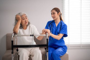 Şefkatli hemşire evde tıbbi destek sunan yaşlı kadınların elini nazikçe tuttu.