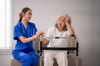 Asyalı hemşire, bakıcıdan duygusal destek arayan yaşlı yetişkinlere şefkat gösteriyor. Yaşlı bakımında empatik profesyonel yardımcılar.