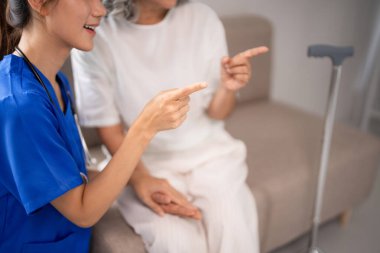 Profesyonel Asyalı bakıcı, yaşlıların refahı için şefkatli bir bakım hizmeti sunan konforlu evde sağlık rehberliği olan yaşlı hastayı destekler.