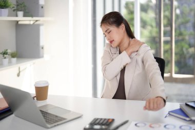Yetişkin Asyalı profesyonel ofis masasında omuz ve boyun rahatsızlığı yaşıyor. Uzun duruş stresinden dolayı işle ilgili ağrı.