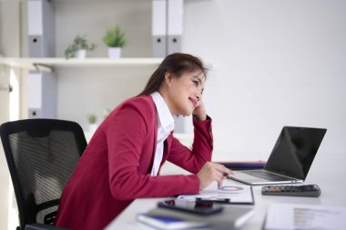 Çalışkan Asyalı profesyonel kadın masasında piyasa verilerini inceliyor. Proje planlaması ve stratejik büyüme için karmaşık bilgileri işliyor..