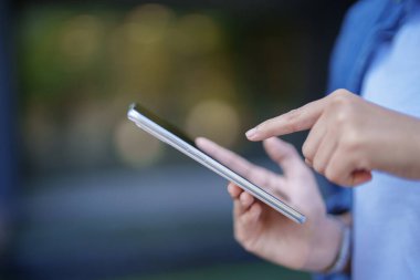 Çevrimiçi ödemeler, sosyal medya tarayıcıları ve finansal işlemler için mobil uygulamalara erişmek için akıllı telefon kullanan bir yetişkin. İletişim teknolojisinin kullanımı