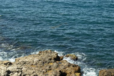 Deniz, küçük kayalara çarpıyor. Okyanus arkaplanı.