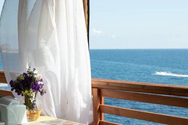 Açık bir yazlık kafeden deniz manzarası, kopyalama alanı. Mavi su ve gökyüzü arkaplanı.