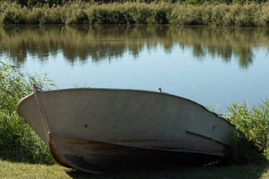 Yüzmek ve balık tutmak için göl kıyısında bir tekne. Orman ve doğa ile ilgili doğal arka plan.