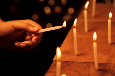Erkek eli, tapınakta, kilisede Diwali gecesinde mum yakar ya da yakar. Festival dekorasyonu, bayram, bayrak, dini ayinler için stok arkaplan resmi.