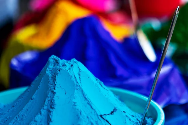 Satıcı çeşitli renklerde holi tozu satıyor, gulal, pazarda abir. Holi hazırlığı için konsept. Arkaplan, grafik kaynakları, broşür, poster, kapak için resim depola.