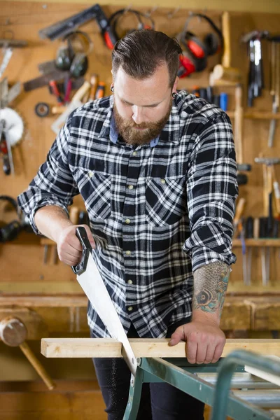 Snickare sågning av trä med hand såg i workshop — Stockfoto