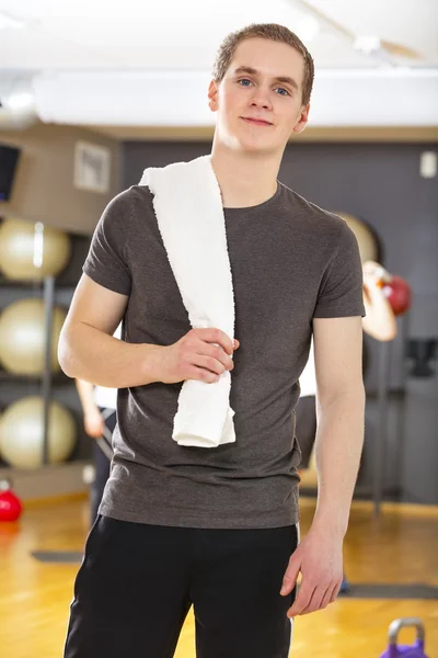 Jovem confiante e sorridente que se exercita no ginásio de fitness — Fotografia de Stock