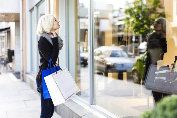 Blonde woman shopper with paper bags in the city Royalty Free Stock Photos