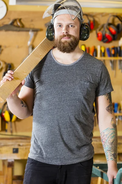 Säker hantverkare med säkerhet mask och öronmuffar i workshop — Stockfoto