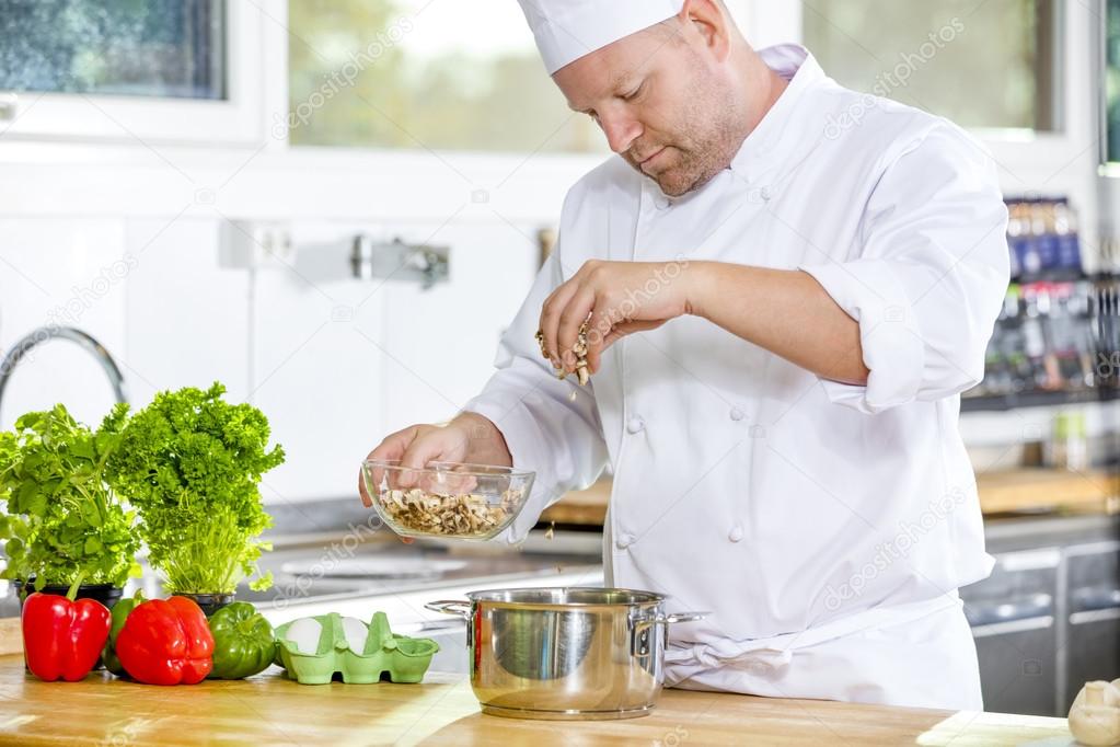 Professional chef preparing dish in large kitchen