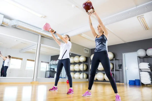 Twee vrouwen treinen met kettlebells op fitness sportschool — Stockfoto