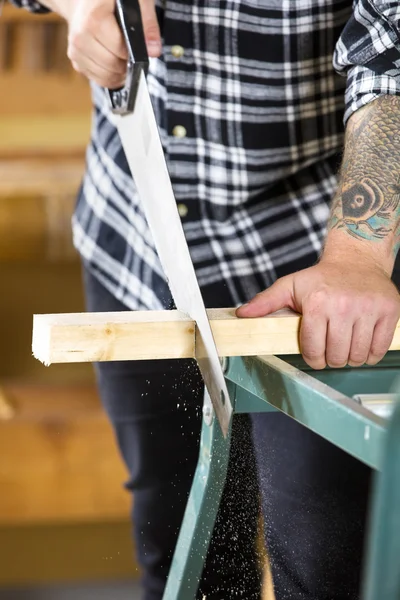 Primer plano de madera aserrada de carpintero con sierra manual — Foto de Stock