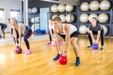 Fitness salonunda kettlebells trenlerle grup odaklı