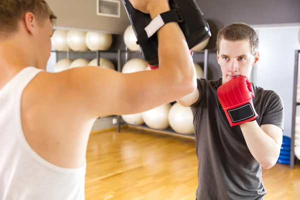 Deux hommes concentrés s'entraînent à la boxe au gymnase de fitness — Photo