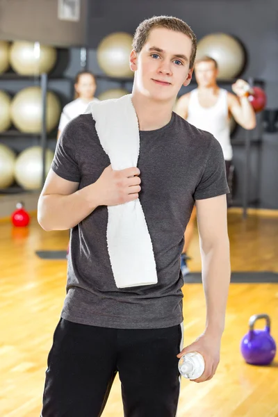 Jovem confiante e sorridente que se exercita no ginásio de fitness — Fotografia de Stock