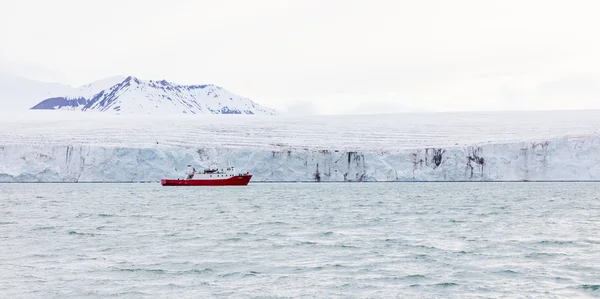 Εκστρατεία βάρκα μπροστά από ένα τεράστιο παγετώνα — Φωτογραφία Αρχείου